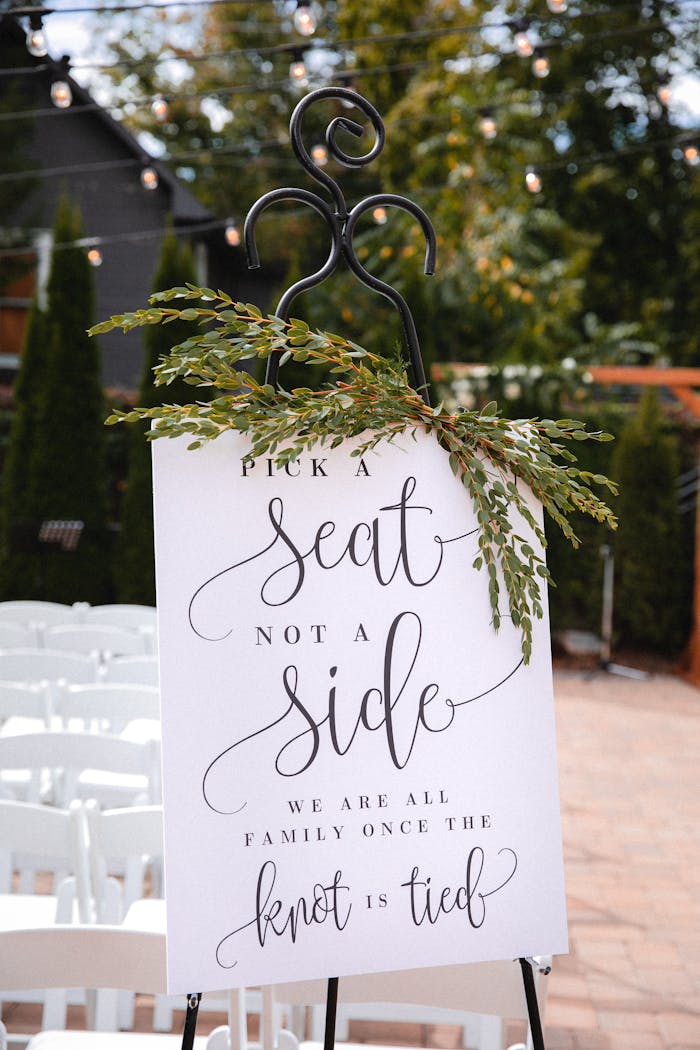 Charming wedding sign outdoors urging guests to 'Pick a Seat Not a Side'.